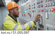 Electrician operates control panel in industrial facility during daytime work shift. Стоковое AI-видео, аниматор Сергей Толмачёв / Фотобанк Лори