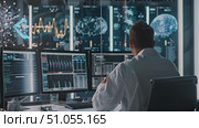 Professional analyzes complex data across multiple computer screens in a modern surveillance office. Стоковое AI-видео, аниматор Данила Большаков / Фотобанк Лори