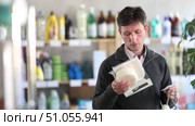 Selective middle-aged male customer choosing convenient body washcloth in large retail store. Стоковое видео, видеограф Яков Филимонов / Фотобанк Лори