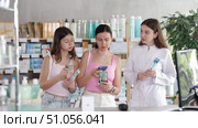 Happy family of adult woman and young girl choosing best toothbrush at big pharmacy and scan QR code on label, female pharmacist consulting and offering variety of goods to customers. Стоковое видео, видеограф Яков Филимонов / Фотобанк Лори