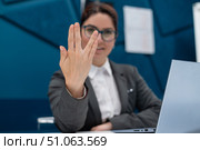 Business woman saying hello in Vulcan style while sitting at her desk in the office. Стоковое фото, фотограф Михаил Решетников / Фотобанк Лори