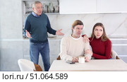 Adult man and young woman discussing inheritance with elderly man in kitchen. Стоковое видео, видеограф Яков Филимонов / Фотобанк Лори