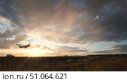 Passenger airplane landing at sunset over highway traffic. Стоковое видео, видеограф Mikhail Davidovich / Фотобанк Лори