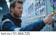 Technician operates control panel in industrial facility during evening shift. Стоковое AI-видео, аниматор Сергей Толмачёв / Фотобанк Лори