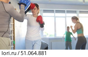 Woman works out strength and speed of boxing punch mitts with help of partner in boxing paws. Стоковое видео, видеограф Яков Филимонов / Фотобанк Лори