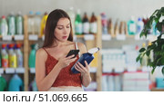 Girl client choose and scanning QR code on package household chemical spray. Стоковое видео, видеограф Яков Филимонов / Фотобанк Лори
