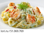 Shrimp Scampi. Spaghetti with shrimp and Creamy Garlic White Wine Sauce on a plate, top view. Scrumptious shrimp and fettuccine pasta with a cilantro, copy space. Linguine Alfredo. Italian cuisine. Стоковое AI-изображение, AI-художник Марина Демидюк / Фотобанк Лори