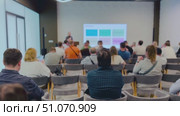 Audience attending a business presentation with colorful slides in a modern conference room. Стоковое видео, видеограф Антон Гвоздиков / Фотобанк Лори