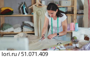 Woman seamstress cutting fabric in sewing workshop. Стоковое видео, видеограф Яков Филимонов / Фотобанк Лори