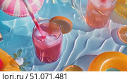 Cool summer drinks with fruit garnishes float in a blue pool. Стоковое AI-видео, аниматор Данила Большаков / Фотобанк Лори