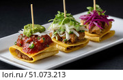 Tostadas with different toppings resting on white rectangular plate. Стоковое AI-изображение, AI-художник Юрий Поздников / Фотобанк Лори