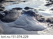 A mud volcano and a stream of grey clay from an eruption and gas escape. Cracked soil surface. Texture of a mudflow. Стоковое фото, фотограф Наталия Кирсанова / Фотобанк Лори