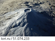A mud volcano and a stream of grey clay from an eruption and gas escape. Cracked soil surface. Texture of a mudflow. Стоковое фото, фотограф Наталия Кирсанова / Фотобанк Лори