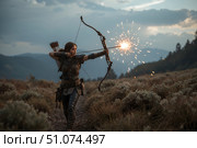 A female archer shoots a bow on the battlefield. Стоковое AI-изображение, AI-художник Александр Поташев / Фотобанк Лори