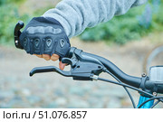 The cyclist's hand is on the handlebars of the bike. Cycling and moving around the city on environmentally friendly transport. Стоковое фото, фотограф Наталия Кирсанова / Фотобанк Лори