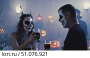 Costumed attendees enjoy a Halloween celebration surrounded by glowing jack-o'-lanterns in a spooky atmosphere. Стоковое AI-видео, аниматор Данила Большаков / Фотобанк Лори