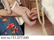 The sacrament of baptism in the Orthodox Church. The priest anoints the child's feet with oil. Стоковое фото, фотограф Екатерина Красникова / Фотобанк Лори