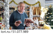 Elderly man choosing jamon in grocery store. Стоковое видео, видеограф Яков Филимонов / Фотобанк Лори