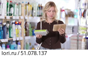 Girl housewife in household store examines goods, chooses clothespin. Стоковое видео, видеограф Яков Филимонов / Фотобанк Лори