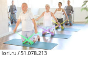 Elderly man teaching pilates with band. Стоковое видео, видеограф Яков Филимонов / Фотобанк Лори