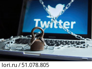 Krasnodar, Russia - March, 04, 2022; A large heavy rusty lock with a chain on a laptop with the Twitter logo. Sanctions and blocking and access restrictions. Редакционное фото, фотограф Наталия Кирсанова / Фотобанк Лори