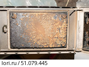 The inside of the solid fuel heater's stove door is heavily soiled and worn. Стоковое фото, фотограф Коханова Наталья / Фотобанк Лори