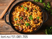 A savory oxtail noodle soup in a rustic Dutch oven. The rich broth, golden noodles, and tender oxtail chunks create a hearty and flavorful meal, perfect for culinary enthusiasts and comfort food lovers. Стоковое AI-изображение, AI-художник Nart / Фотобанк Лори