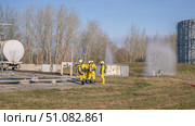 A group of rescuers equipped with breathing apparatus at the scene of an accident at a petrochemical plant. Elimination of an accident at a petrochemical plant. There is an emergency at the factory. Стоковое фото, фотограф Эдуард Белкин / Фотобанк Лори