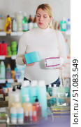 Young pregnant woman in store carefully examining packs of panty liners, selecting best option for daily comfort and freshness during pregnancy. Стоковое видео, видеограф Яков Филимонов / Фотобанк Лори