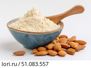 Almond flour. Almond nuts and almond flour in a wooden bowl and spoon. White table background. Grated almonds pile. Gluten-free produce for health. Low Carb Keto, celiac, paleo, and wheat-free diets. Стоковое AI-изображение, AI-художник Марина Демидюк / Фотобанк Лори