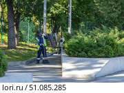 Дворник в спецодежде подметает мусор на набережной реки Кама в Перми. Редакционное фото, фотограф Ирина Старкова / Фотобанк Лори
