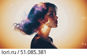 A young woman with long dark hair is depicted in profile. Her silhouette is filled with a vibrant cosmic scene, showcasing stars and galaxies. Стоковое AI-видео, аниматор Nart / Фотобанк Лори