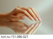 Perfectly manicured hand with glossy finish resting on reflective surface. Стоковое AI-изображение, AI-художник Katsiaryna Repich / Фотобанк Лори