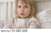 4 years girl joking, sticking tongue out with silly expression. Child making face. Funny foolishness portrait of little kid doing crazy comical gesture among a white wall. Closeup face. Low contrast. Стоковое видео, видеограф Марина Демидюк / Фотобанк Лори