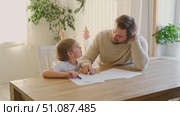 Dad teaches his son writing and counting. Kids primary education. Children learn, study in home school. Daddy male helping teaching little child boy support studying, learning homework. Knowledge day. Стоковое видео, видеограф Марина Демидюк / Фотобанк Лори