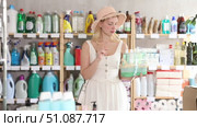 Young woman view trademark sign on label, chooses eco friendly present bath cosmetic kit. Стоковое видео, видеограф Яков Филимонов / Фотобанк Лори