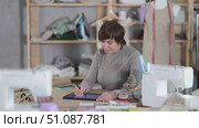 Female dressmaker working on digital sketch of dress in workshop. Стоковое видео, видеограф Яков Филимонов / Фотобанк Лори