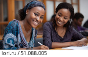 Female African students reading together in a library, surrounded by books and quiet study space. Black African children from disadvantaged families study in school, read books, receive primary education, volunteer service. Стоковое AI-изображение, AI-художник ALLA YURTAYEVA / Фотобанк Лори