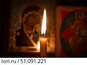 Горящая церковная свеча перед православными иконами. Стоковое фото, фотограф Павел Авакумов / Фотобанк Лори