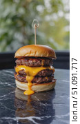 A Towering Cheeseburger Exuding Melted Cheese and Juicy Patties, Perfectly Posed on a Marble Surface, Captures the Essence of Indulgent Fast Food Delight. Стоковое AI-видео, аниматор Владимир Федоров / Фотобанк Лори