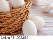 Basket with white eggs. White eggs in a wicker basket. Broken egg shells next to whole eggs. Simple composition. Стоковое фото, фотограф Анастасия  Гудантова / Фотобанк Лори