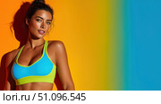 Woman in athletic wear poses confidently against a vibrant background. Стоковое AI-изображение, AI-художник Ксения Лаптева / Фотобанк Лори