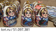 Souvenir bells from Karelia. The bells are made of ceramics, painted with bright colors and decorated with an image of a girl in the traditional Russian style - with pigtails, rosy cheeks and a flower headband. The lower part of the bells depicts picturesque landscapes of Karelia: rocks, rivers, forests, lakes and elks, emphasizing the natural wealth of the region. Each bell is equipped with a golden hanging thread, which allows it to be used as a souvenir or New Year's decoration. The composition emphasizes the ethnic flavor and tourist appeal of Karelia. Стоковое фото, фотограф Анна Кривицкая / Фотобанк Лори