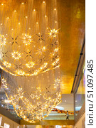 An impressive star-patterned chandelier hangs from the ceiling of the luxury shopping mall Iconsiam. Thailand, Bangkok (2024 год). Редакционное фото, фотограф Коханова Наталья / Фотобанк Лори