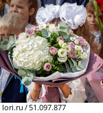 1 сентября большой красивый букет цветов в руках у школьницы с белыми бантами (2024 год). Редакционное фото, фотограф FOTOvZAPASE / Фотобанк Лори