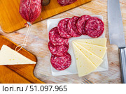 Sliced cured Spanish sausage and cheese on serving plate. Стоковое фото, фотограф Яков Филимонов / Фотобанк Лори