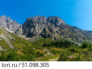 Ala-Archa Alpine Camp Kyrgyzstan shows jagged walls scree slopes conifer forest. Meadow, stream, trekking approaches mountaineering routes, climbing objectives backpacking, daytrip adventure summit. Стоковое фото, фотограф Андрей Ка / Фотобанк Лори