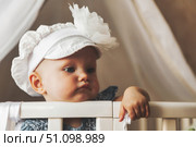 Sweet Dreams in a Floral Bonnet Baby Girl Rests in Her Crib. Стоковое фото, фотограф Aleksandr Golubev / Фотобанк Лори