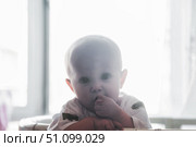 Little One Ponders Softly in a Brightly Lit Crib, Dreaming of Tomorrow. Стоковое фото, фотограф Aleksandr Golubev / Фотобанк Лори