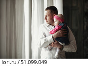 Daddy's First Look Into the World With His Daughter Near Window. Стоковое фото, фотограф Aleksandr Golubev / Фотобанк Лори